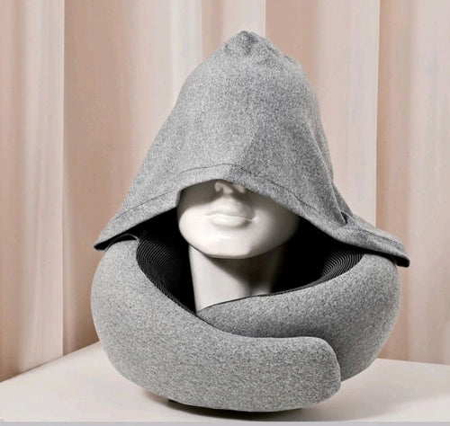 Hooded travel pillow with light-blocking hood and 360-degree memory foam neck support. Gray color, soft polyester cover with drawstring adjustment. Compact and rollable for travel. Ships from San Mateo California.